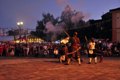 Jarmark Jarosławski Cztery przebrane osoby oddają strzał, w tle publiczność