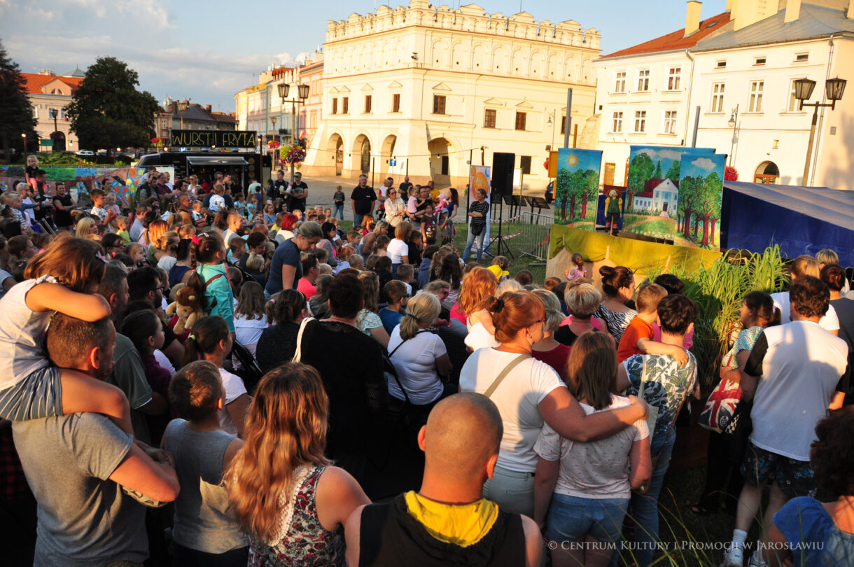Grupa ludzi oglądająca teatrzyk kukiełkowy