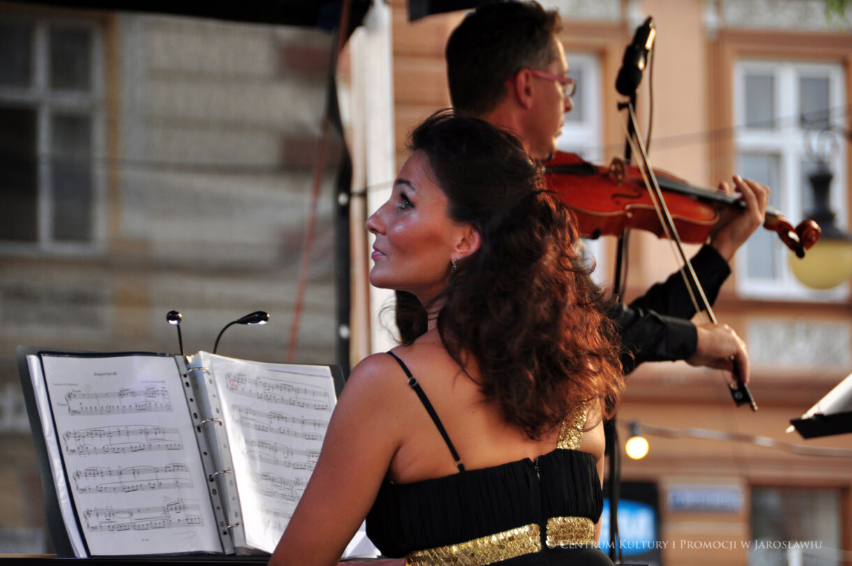 Kobieta przy pianinie, w tle mężczyzna ze skrzypcami