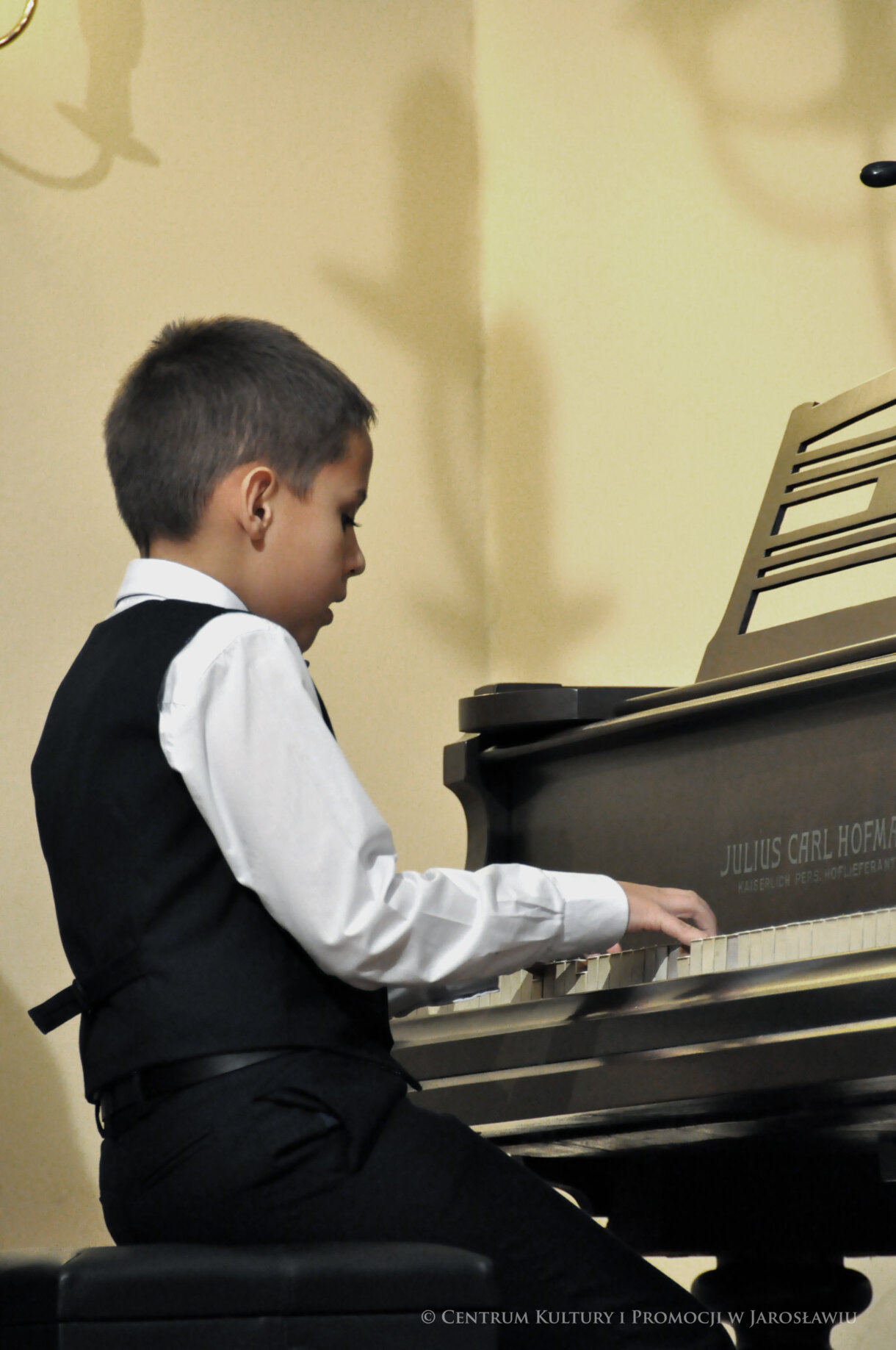 uczeń Szkoły Muzycznej gra na fortepianie kolędy