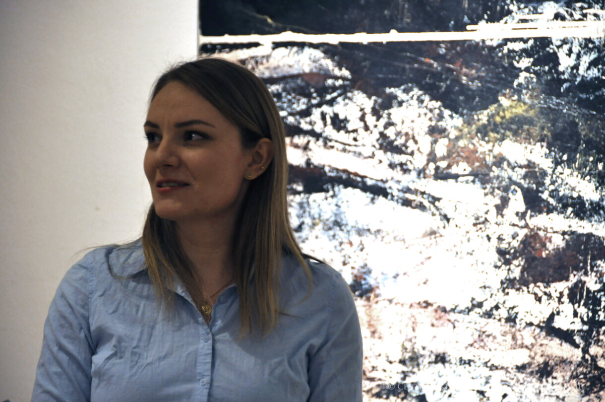 Agnieszka Sacała autorka wystawy, na tle swojego obrazu