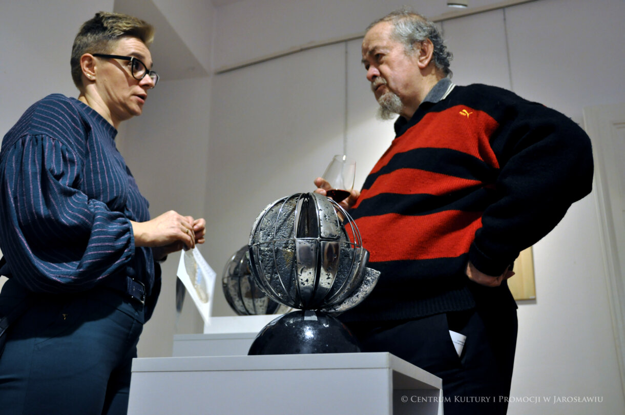 uczestnicy wernisażu rozmawiają nad rzeźbą