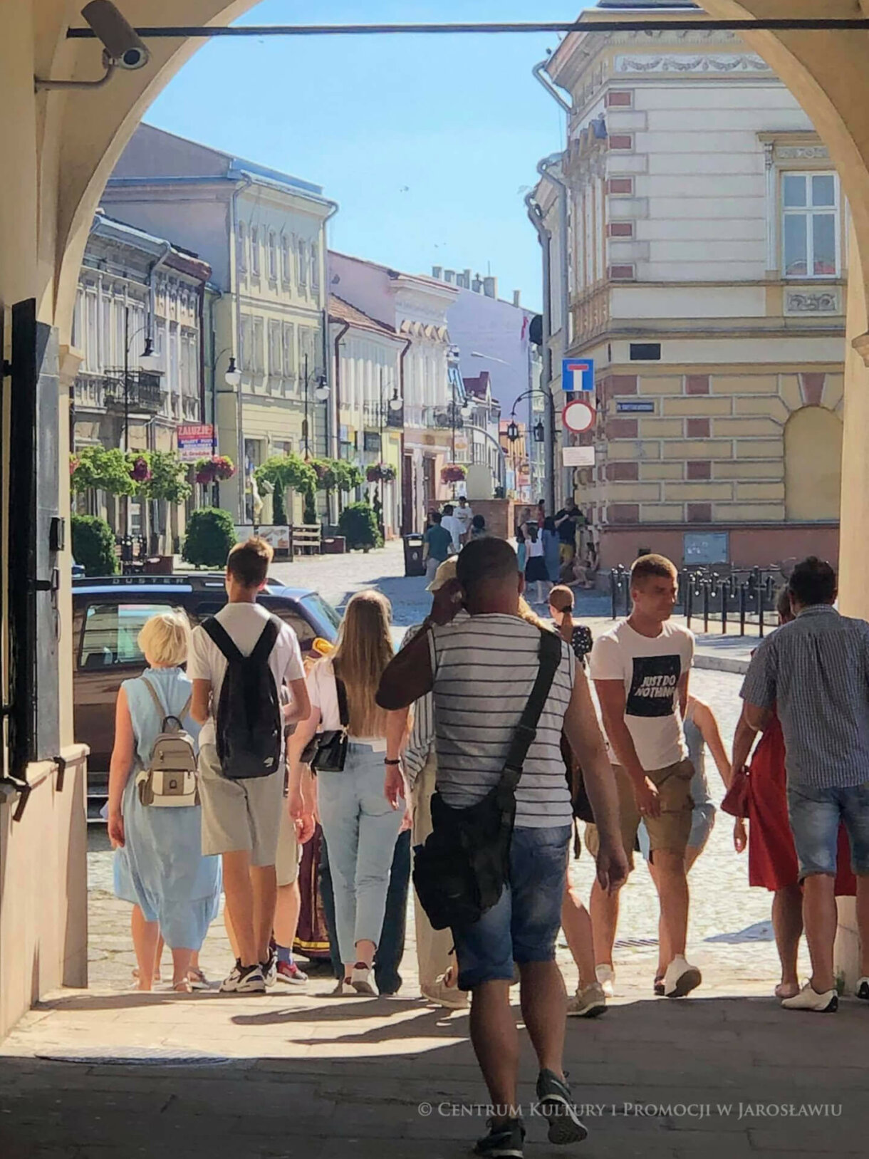 Grupa podążająca podcieniami kamienicy Orsettich