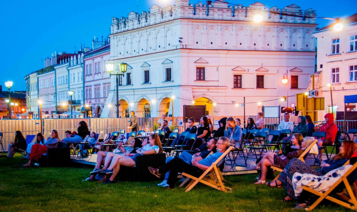 Ludzie na leżakach, w tle kamienica Orsettich