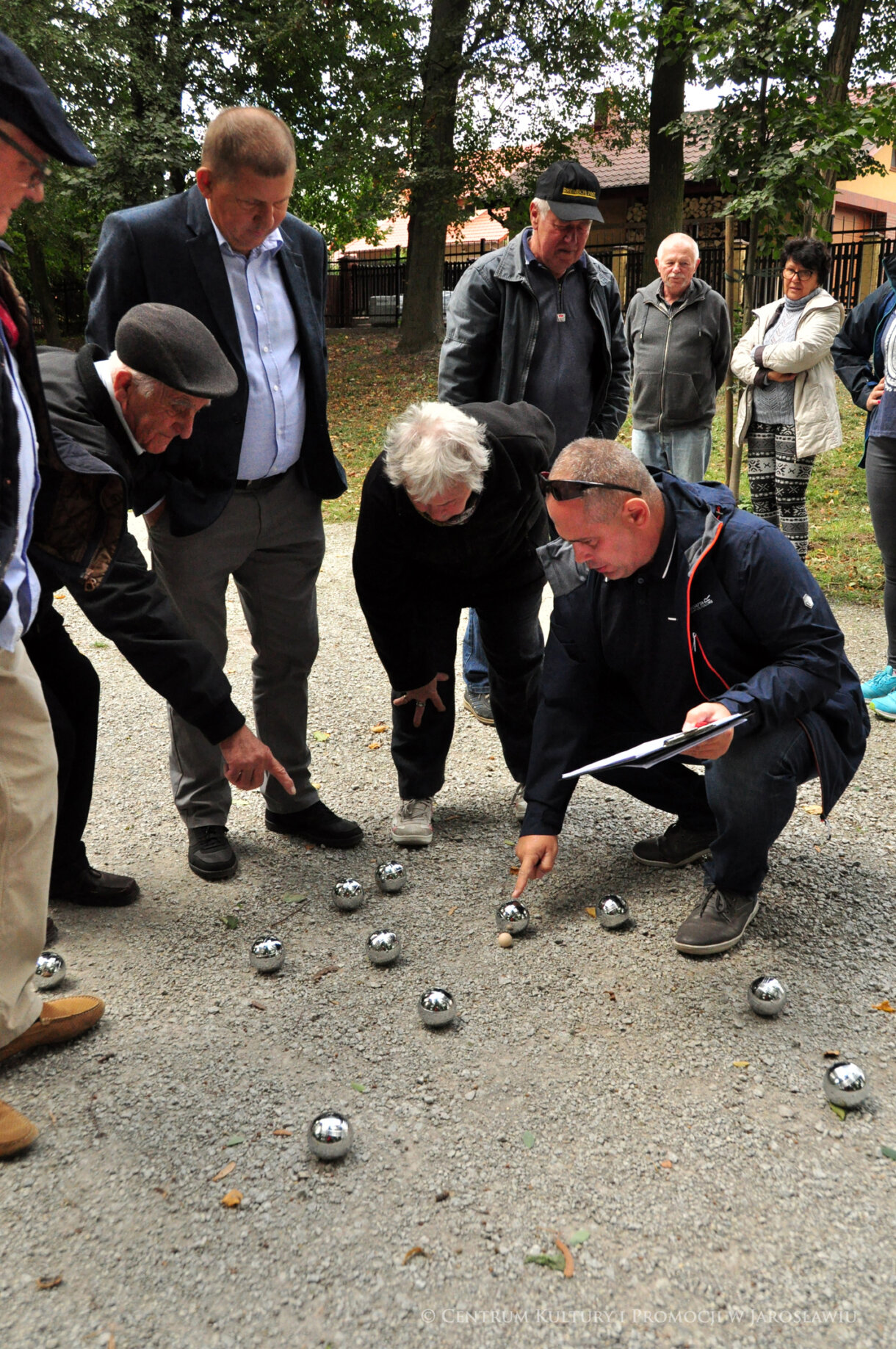 Grupa ludzi sprawdzająca wyniki gry w bule