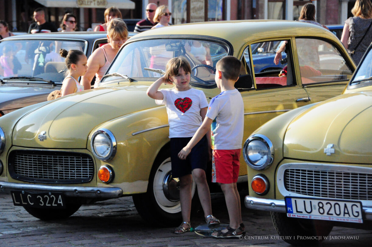 Dwoje dzieci przy samochodzie