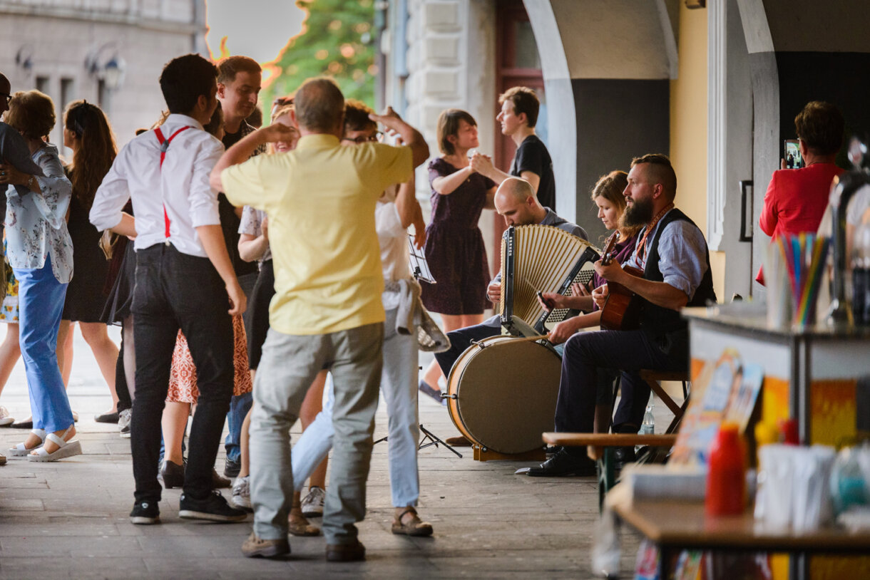 Ludzie tańczący w podcieniach kamienicy Rynek 14