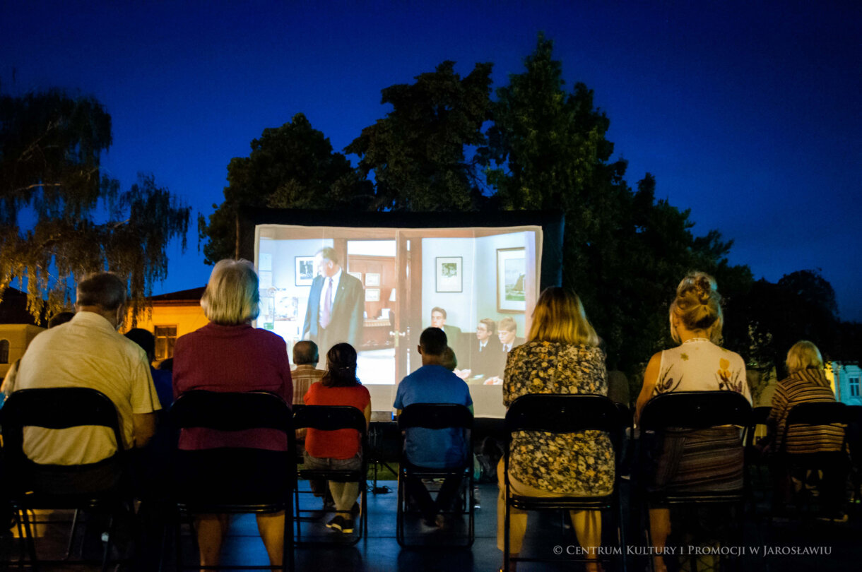 od tyłu widzowie na krzesłach, w tle ekran filmowy