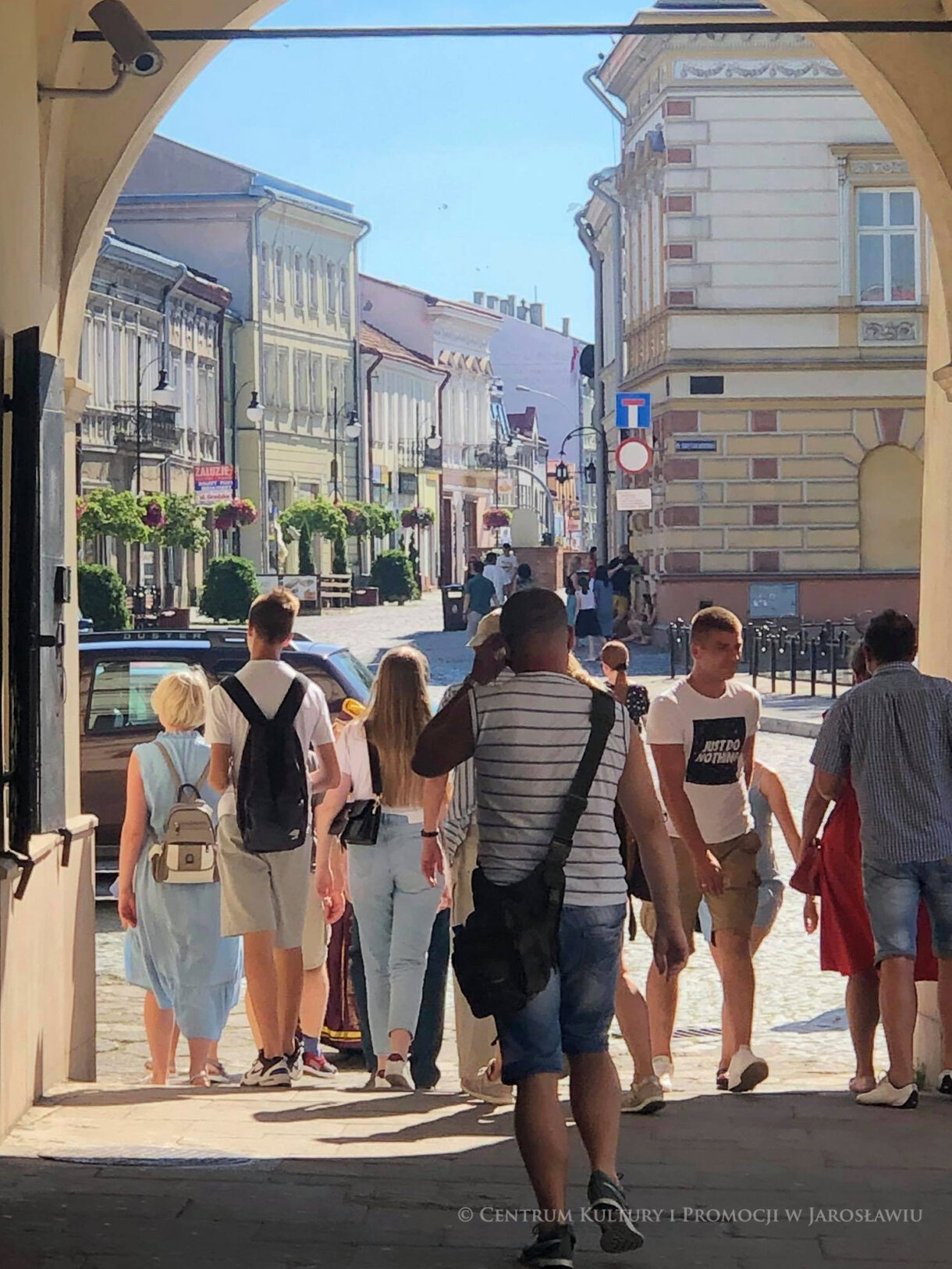 Grupa podążająca podcieniami kamienicy Orsettich