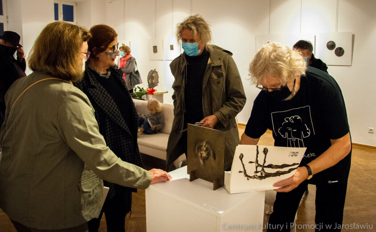 Artysta podpisuje pamiątkowy katalog