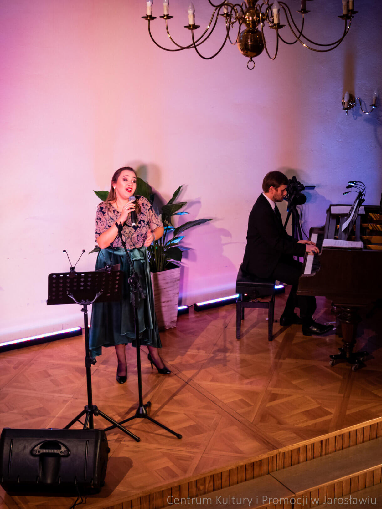 Wokalistka na scenie podczas koncertu obok pianista gra na fortepianie