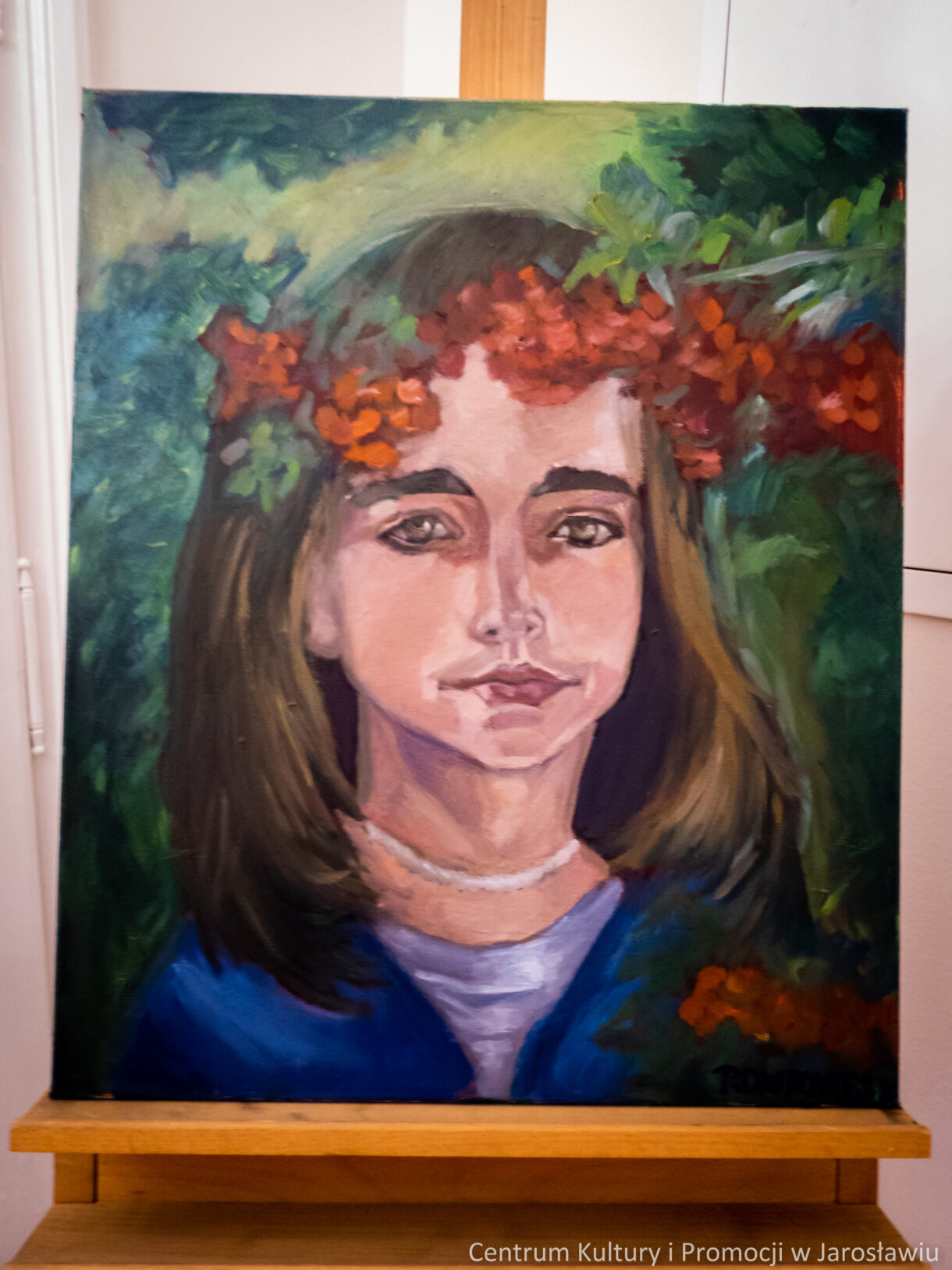 Malarstwo. Młoda dziewczyna z wiankiem z czerwonych kwiatów na głowie