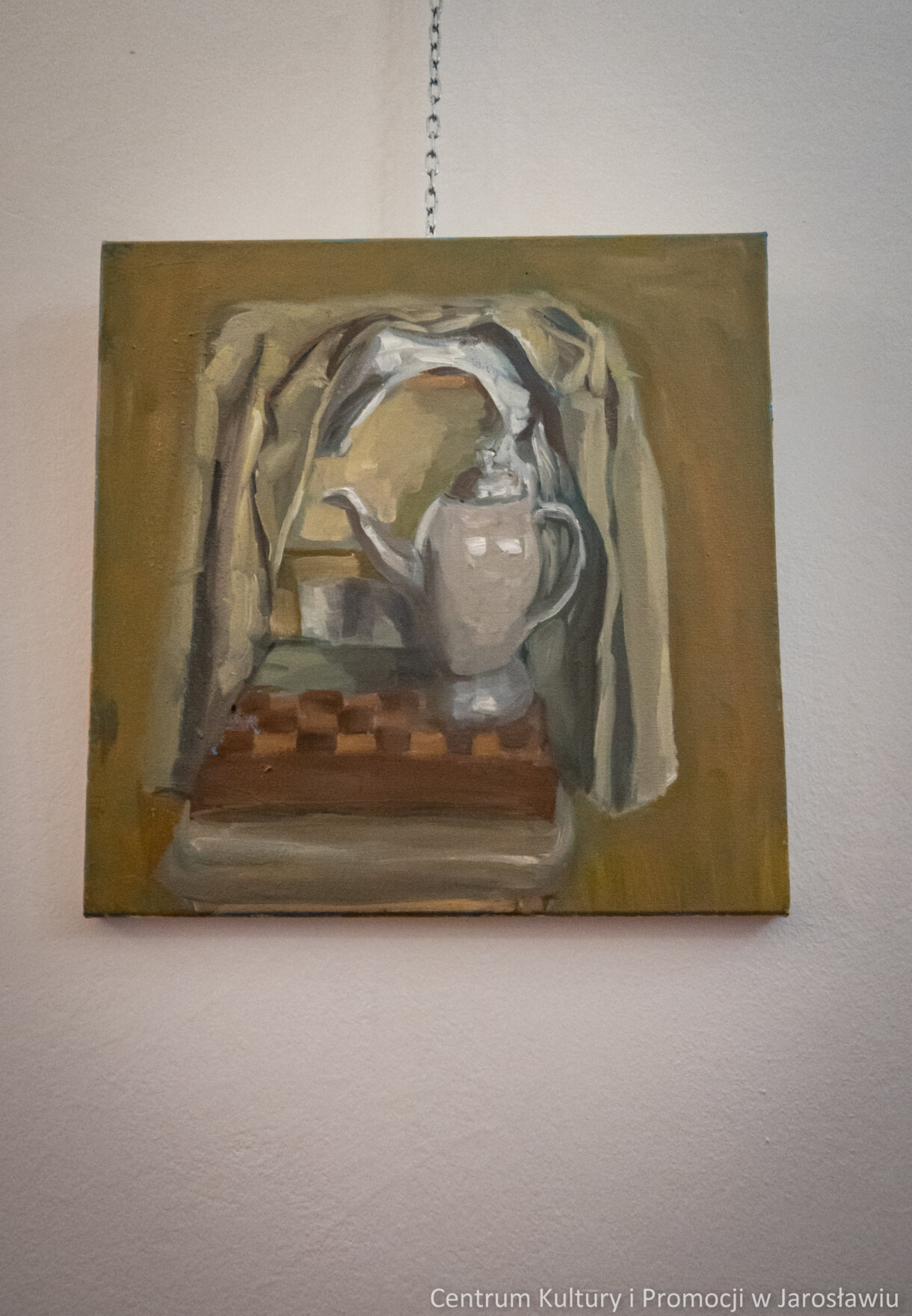 Malarstwo, obraz w odcieniach brązu i szarości. Marynarka powieszona na oparciu krzesła, na krześle szachownica oraz imbryk