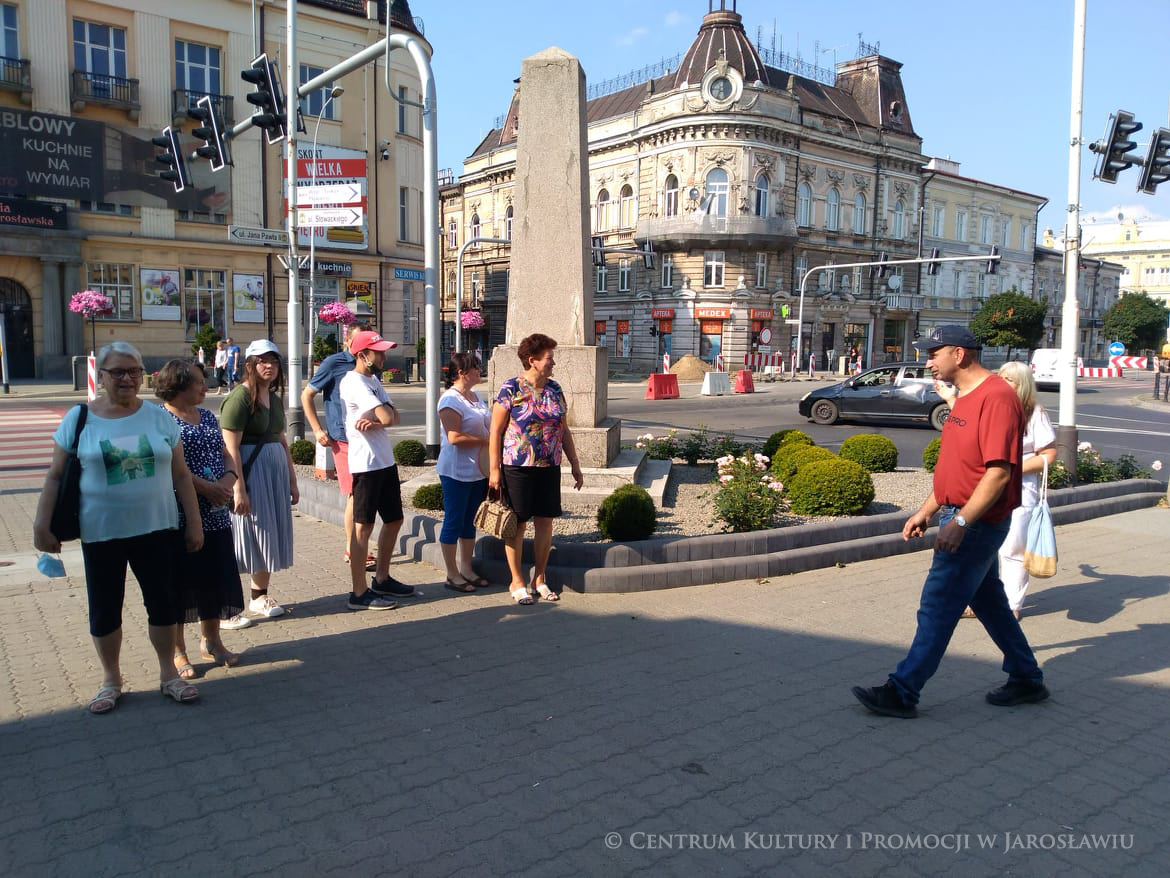 Grupa ludzi przy pomniku na skrzyżowaniu ulic Jana Pawła II i Słowackiego