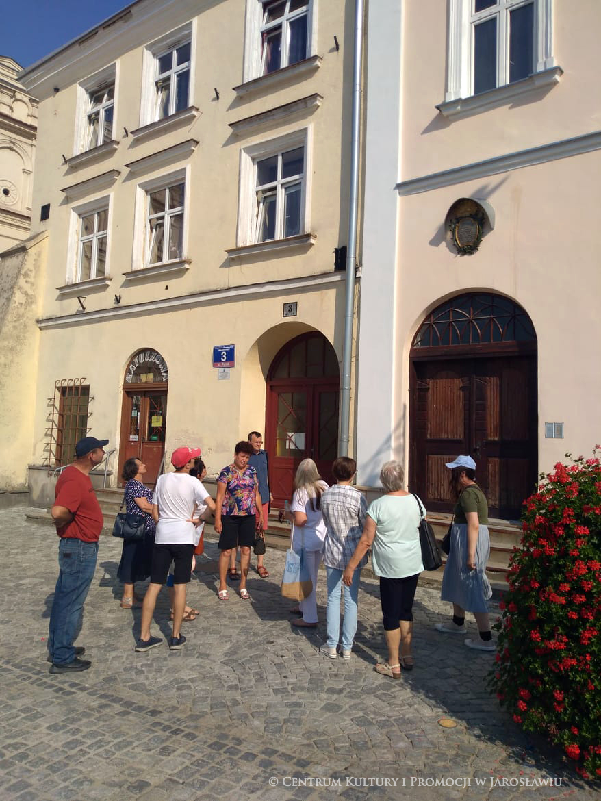 Grupa ludzi przy kamienicach Rynek 2 i 3
