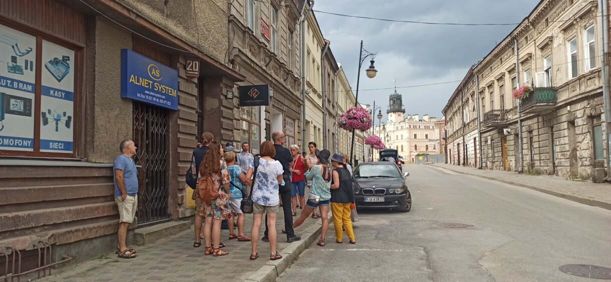 Grupa ludzi przed przed kamienicami na ulicy Grodzkiej w Jarosławiu