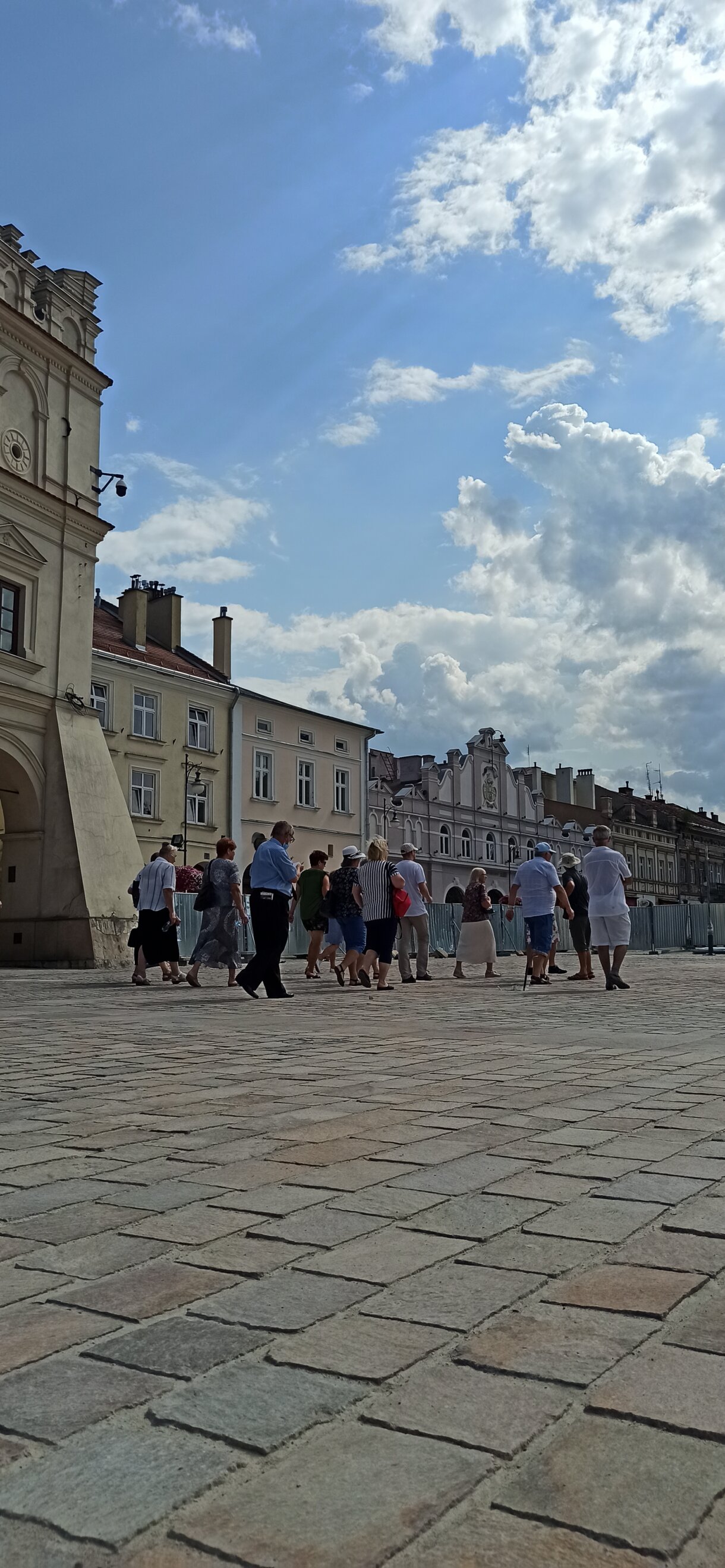 grupa osób podczas zwiedzania miasta przed kamienicą orsettich