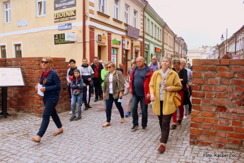 Grupa ludzi przechodząca przez Bramę Krakowską, foto Kacper Loc