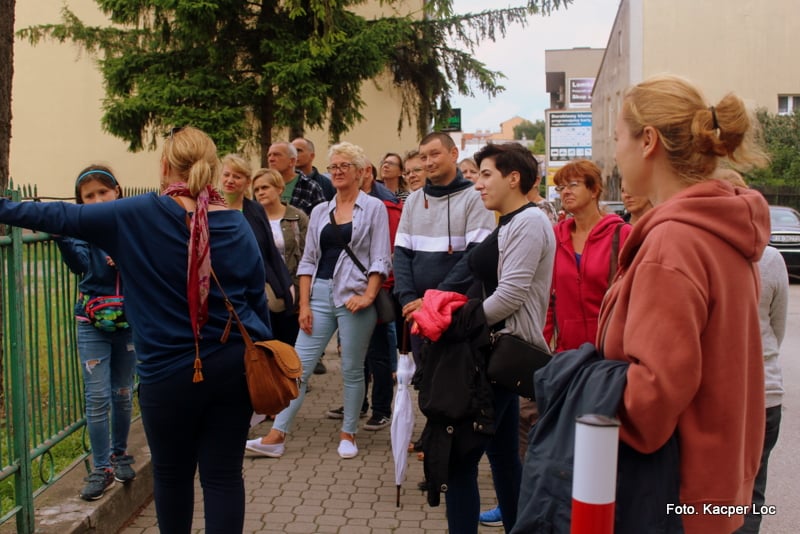 Grupa ludzi przy ogrodzeniu, foto Kacper Loc
