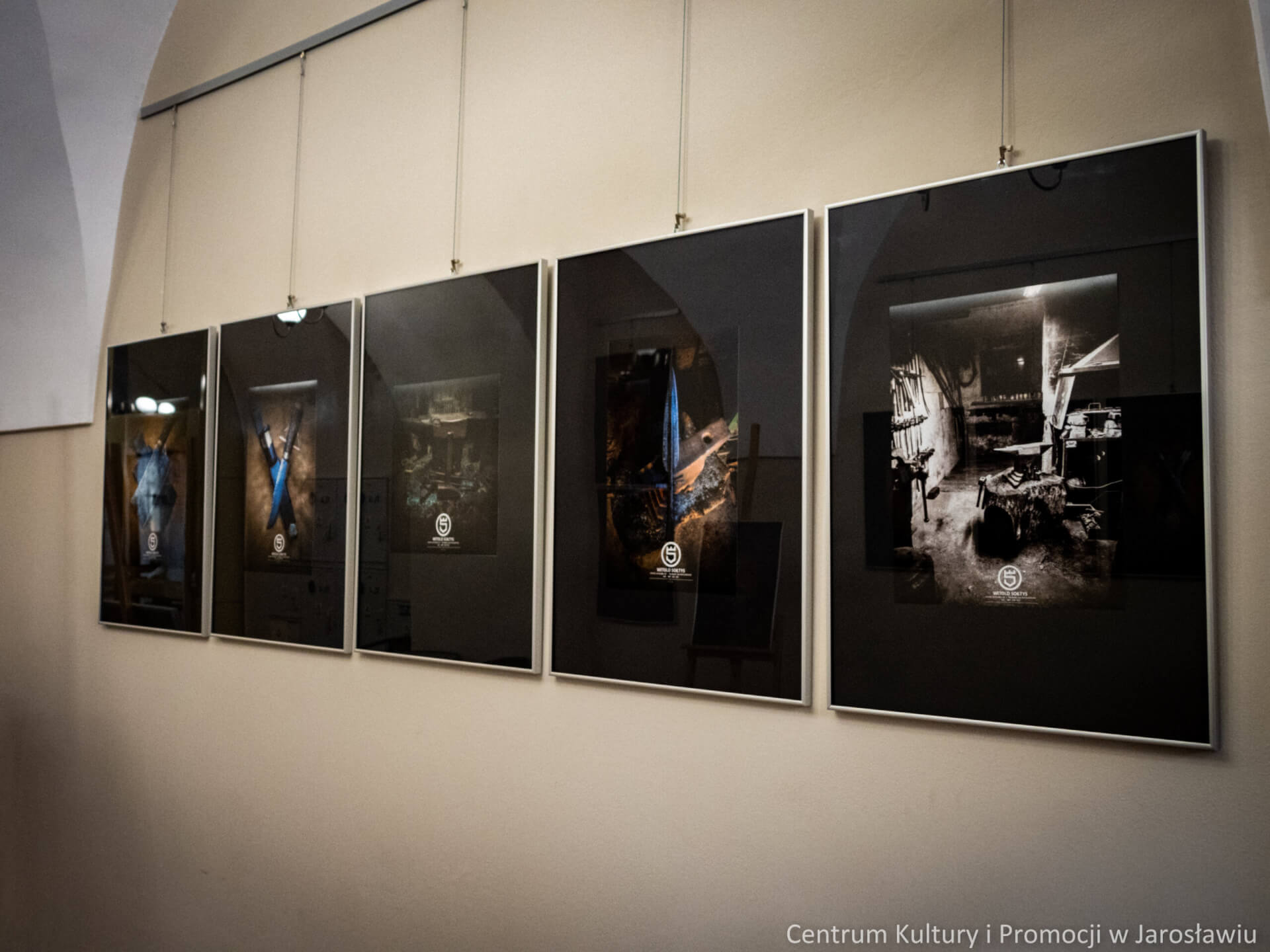 na ścianach fotografie ukazujące sztukę kowalską