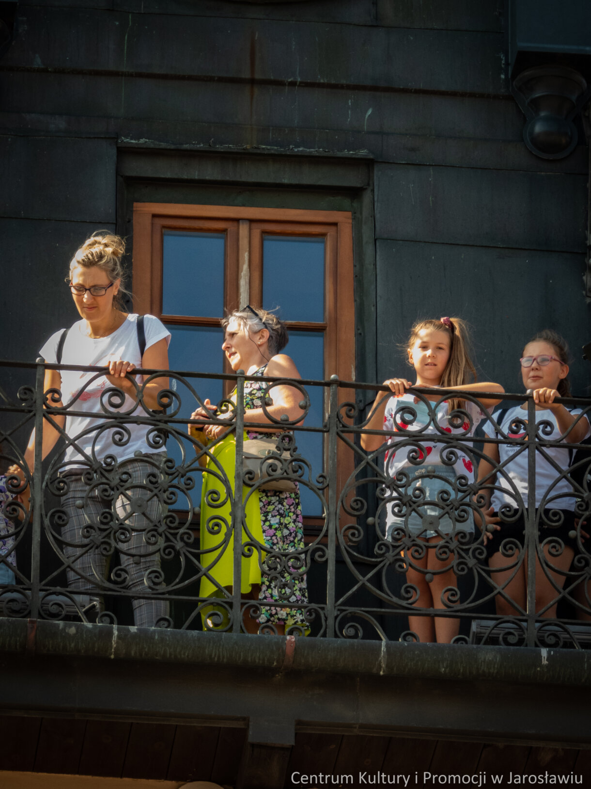 grupa osób zwiedzających miasta na wieży ratuszowej