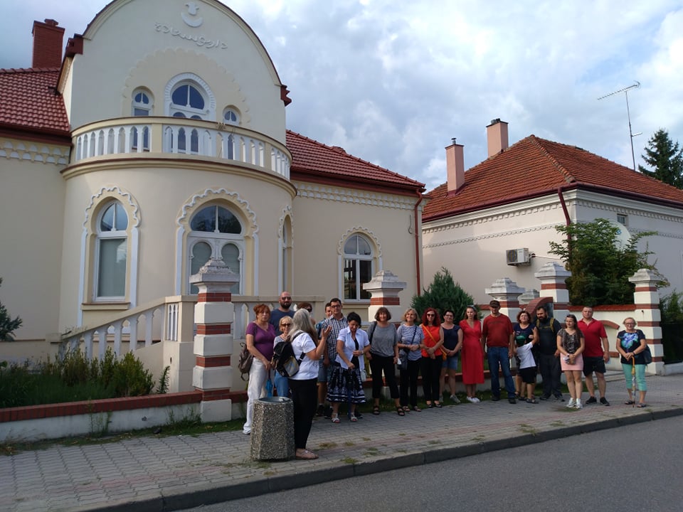 grupa osób podczas zwiedzania miasta przed kamienicami na rynku