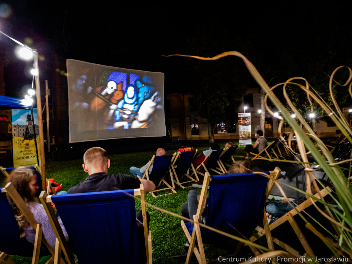 ekran kina plenerowego z perspektywy widzów uczestniczących w seansie