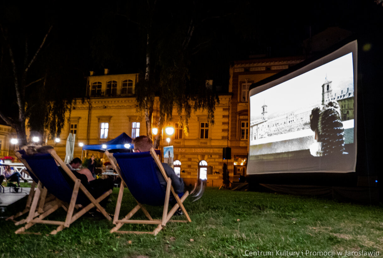ekran kina plenerowego z perspektywy widzów uczestniczących w seansie