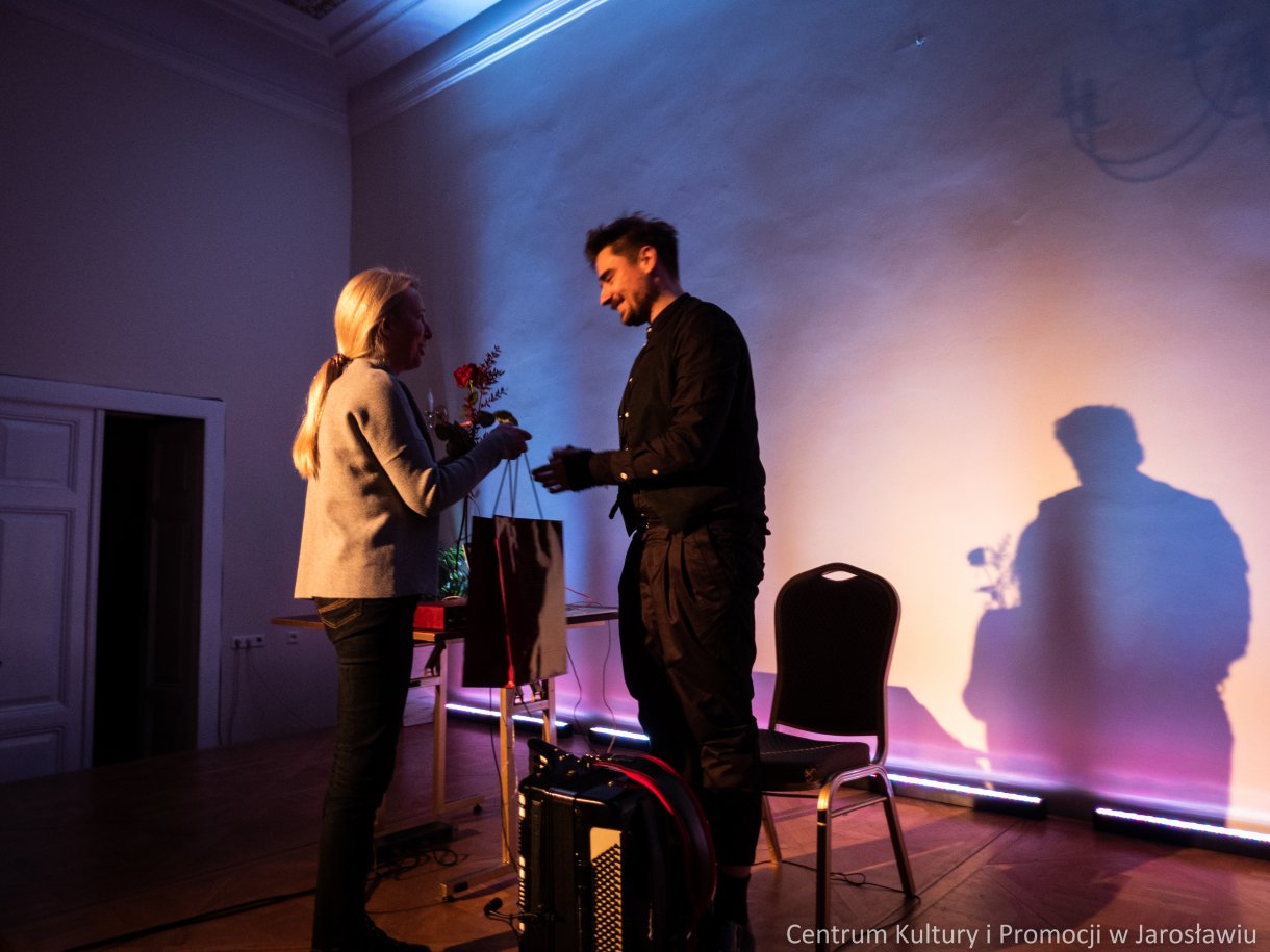 Kierownik działu organizacyjno - artystycznego wręcza kwiaty i podziękowania za koncert Patrykowi Walczakowi