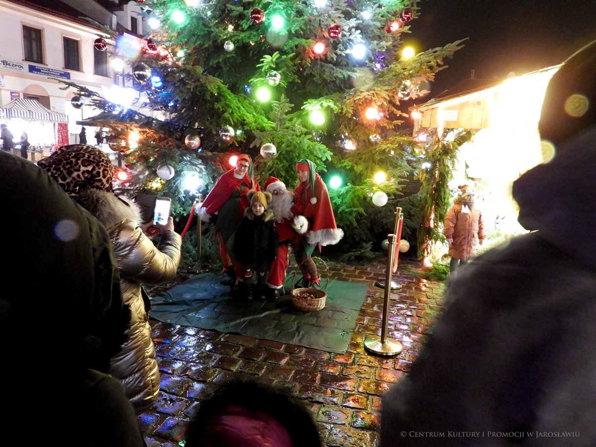 Dziecko pozująe z Mikołajem i skrzatami