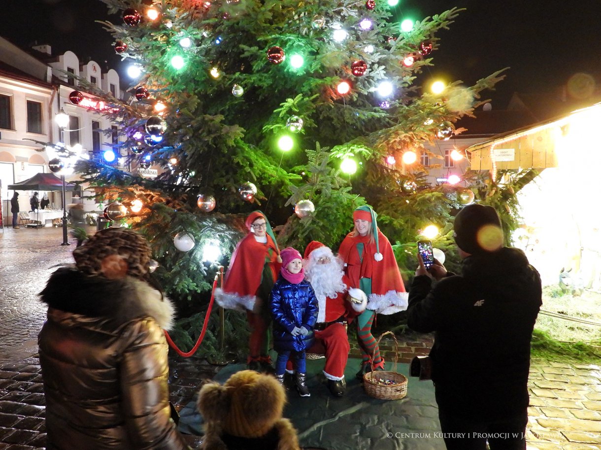 Dziecko pozująe z Mikołajem i skrzatami