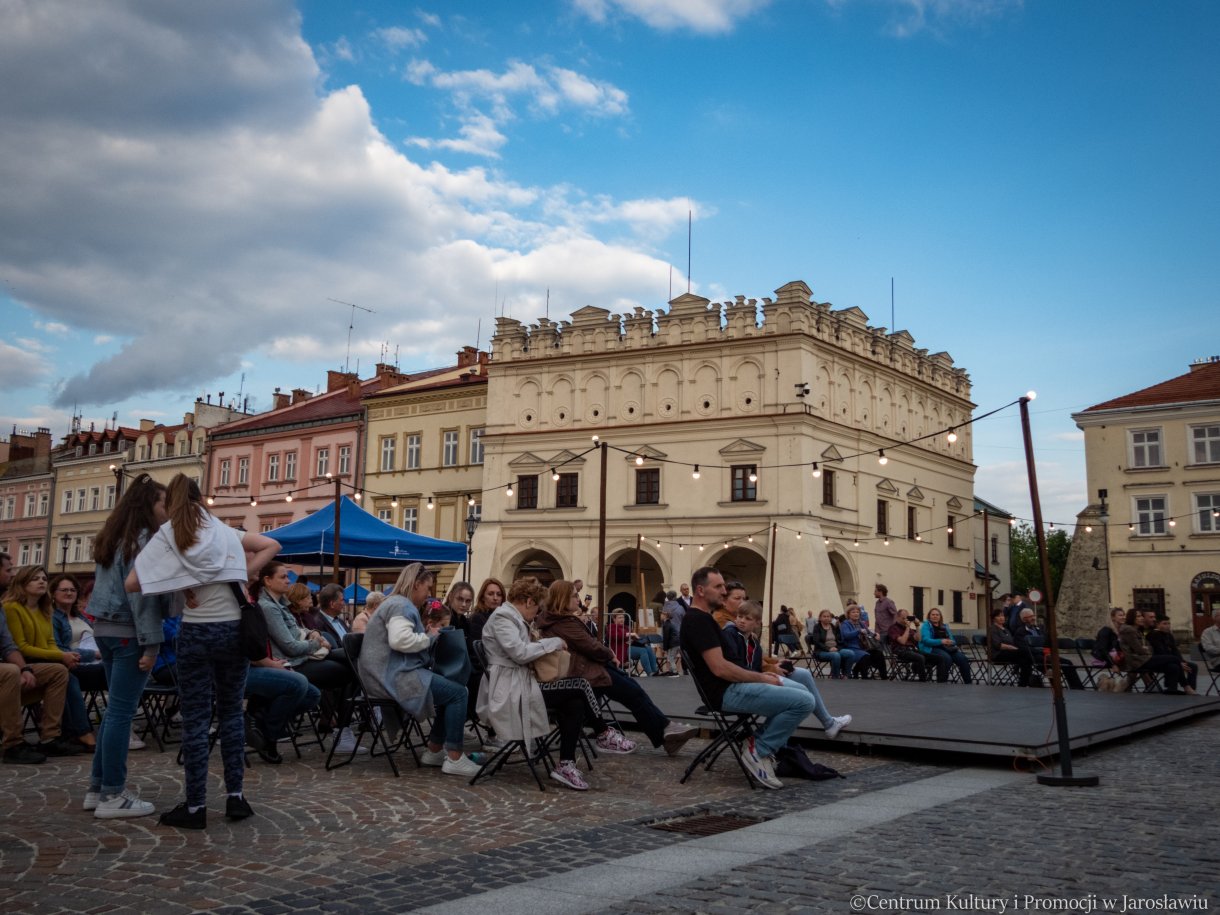 publiczność słuchająca koncertu w tle kamienica orsettich
