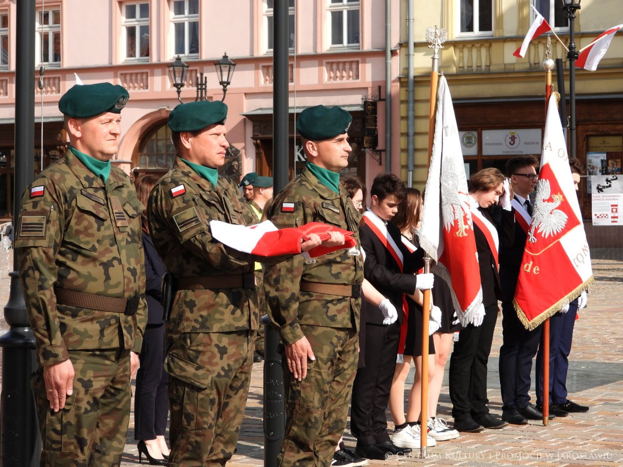 Początek maja to czas upamiętniający jedne z najważniejszych wydarzeń i symboli w naszej historii. Od 2004 roku w całej Polsce, 2 maja obchodzimy Dzień Flagi RP natomiast 3 maja przypada Święto Narodowe Trzeciego Maja. Dzień Flag RP to święto wprowadzone na mocy ustawy z 20 lutego 2004 r. Jarosławskie obchody Święta Flagi RP rozpoczęły się uroczystym przemarszem z placu ks. Piotra Skargi na jarosławski Rynek. Biało-czerwony korowód niosący 30-metrową flagę prowadzony był przez Orkiestrę Dętą „Laudate Dominum” oraz kompanię reprezentacyjna Wojska Polskiego. Po dotarciu na rynek, uroczyście podniesiono flagę na masz. Towarzyszył temu odegrany przez „Laudate Dominum” oraz odśpiewany przez żołnierzy i wszystkich zebranych Mazurek Dąbrowskiego. Okolicznościowe przemówienie wygłosił min. Burmistrz Miasta Jarosławia Waldemar Paluch, który podkreślał wagę symboli narodowych w tym szczególnym czasie, po czym miała miejsce defilada wojskowa. Na zakończenie obchodów rozdane zostały biało-czerwone flagi, wykonano wspólne pamiątkowe zdjęcie, a dzieci mogły wziąć udział w specjalnie dla nich przygotowanych animacjach i zabawach. Święto Narodowe Trzeciego Maja otworzył koncert Reprezentacyjnego Chóru Mieszanego „Jarosław”, który poprzedził mszę święto w intencji Ojczyzny, odprawioną w kościele p.w. NMP Królowej Polski. Po eucharystii udano się pod pomnik Konstytucji Trzeciego Maja gdzie w towarzystwie Mazurka Dąbrowskiego podniesiono flagę na maszt. Po okolicznościowych przemówieniach odczytana apel pamięci, następnie kompania honorowa Wojska Polskiego oddała salwę honorową. Później nastąpiło złożenie kwiatów pod Pomnikiem przez władze parlamentarzystów, władze wojewódzkie i samorządowe, służby i instytucje publiczne, organizacje pozarządowe oraz szkoły.