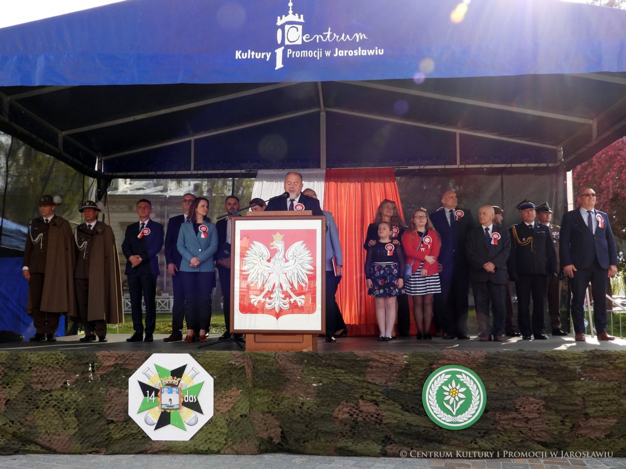 Początek maja to czas upamiętniający jedne z najważniejszych wydarzeń i symboli w naszej historii. Od 2004 roku w całej Polsce, 2 maja obchodzimy Dzień Flagi RP natomiast 3 maja przypada Święto Narodowe Trzeciego Maja. Dzień Flag RP to święto wprowadzone na mocy ustawy z 20 lutego 2004 r. Jarosławskie obchody Święta Flagi RP rozpoczęły się uroczystym przemarszem z placu ks. Piotra Skargi na jarosławski Rynek. Biało-czerwony korowód niosący 30-metrową flagę prowadzony był przez Orkiestrę Dętą „Laudate Dominum” oraz kompanię reprezentacyjna Wojska Polskiego. Po dotarciu na rynek, uroczyście podniesiono flagę na masz. Towarzyszył temu odegrany przez „Laudate Dominum” oraz odśpiewany przez żołnierzy i wszystkich zebranych Mazurek Dąbrowskiego. Okolicznościowe przemówienie wygłosił min. Burmistrz Miasta Jarosławia Waldemar Paluch, który podkreślał wagę symboli narodowych w tym szczególnym czasie, po czym miała miejsce defilada wojskowa. Na zakończenie obchodów rozdane zostały biało-czerwone flagi, wykonano wspólne pamiątkowe zdjęcie, a dzieci mogły wziąć udział w specjalnie dla nich przygotowanych animacjach i zabawach. Święto Narodowe Trzeciego Maja otworzył koncert Reprezentacyjnego Chóru Mieszanego „Jarosław”, który poprzedził mszę święto w intencji Ojczyzny, odprawioną w kościele p.w. NMP Królowej Polski. Po eucharystii udano się pod pomnik Konstytucji Trzeciego Maja gdzie w towarzystwie Mazurka Dąbrowskiego podniesiono flagę na maszt. Po okolicznościowych przemówieniach odczytana apel pamięci, następnie kompania honorowa Wojska Polskiego oddała salwę honorową. Później nastąpiło złożenie kwiatów pod Pomnikiem przez władze parlamentarzystów, władze wojewódzkie i samorządowe, służby i instytucje publiczne, organizacje pozarządowe oraz szkoły.