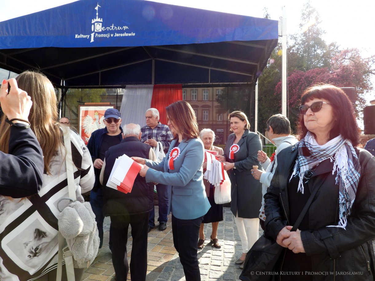 Początek maja to czas upamiętniający jedne z najważniejszych wydarzeń i symboli w naszej historii. Od 2004 roku w całej Polsce, 2 maja obchodzimy Dzień Flagi RP natomiast 3 maja przypada Święto Narodowe Trzeciego Maja. Dzień Flag RP to święto wprowadzone na mocy ustawy z 20 lutego 2004 r. Jarosławskie obchody Święta Flagi RP rozpoczęły się uroczystym przemarszem z placu ks. Piotra Skargi na jarosławski Rynek. Biało-czerwony korowód niosący 30-metrową flagę prowadzony był przez Orkiestrę Dętą „Laudate Dominum” oraz kompanię reprezentacyjna Wojska Polskiego. Po dotarciu na rynek, uroczyście podniesiono flagę na masz. Towarzyszył temu odegrany przez „Laudate Dominum” oraz odśpiewany przez żołnierzy i wszystkich zebranych Mazurek Dąbrowskiego. Okolicznościowe przemówienie wygłosił min. Burmistrz Miasta Jarosławia Waldemar Paluch, który podkreślał wagę symboli narodowych w tym szczególnym czasie, po czym miała miejsce defilada wojskowa. Na zakończenie obchodów rozdane zostały biało-czerwone flagi, wykonano wspólne pamiątkowe zdjęcie, a dzieci mogły wziąć udział w specjalnie dla nich przygotowanych animacjach i zabawach. Święto Narodowe Trzeciego Maja otworzył koncert Reprezentacyjnego Chóru Mieszanego „Jarosław”, który poprzedził mszę święto w intencji Ojczyzny, odprawioną w kościele p.w. NMP Królowej Polski. Po eucharystii udano się pod pomnik Konstytucji Trzeciego Maja gdzie w towarzystwie Mazurka Dąbrowskiego podniesiono flagę na maszt. Po okolicznościowych przemówieniach odczytana apel pamięci, następnie kompania honorowa Wojska Polskiego oddała salwę honorową. Później nastąpiło złożenie kwiatów pod Pomnikiem przez władze parlamentarzystów, władze wojewódzkie i samorządowe, służby i instytucje publiczne, organizacje pozarządowe oraz szkoły.