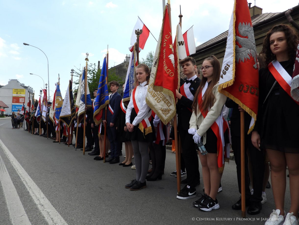 Początek maja to czas upamiętniający jedne z najważniejszych wydarzeń i symboli w naszej historii. Od 2004 roku w całej Polsce, 2 maja obchodzimy Dzień Flagi RP natomiast 3 maja przypada Święto Narodowe Trzeciego Maja. Dzień Flag RP to święto wprowadzone na mocy ustawy z 20 lutego 2004 r. Jarosławskie obchody Święta Flagi RP rozpoczęły się uroczystym przemarszem z placu ks. Piotra Skargi na jarosławski Rynek. Biało-czerwony korowód niosący 30-metrową flagę prowadzony był przez Orkiestrę Dętą „Laudate Dominum” oraz kompanię reprezentacyjna Wojska Polskiego. Po dotarciu na rynek, uroczyście podniesiono flagę na masz. Towarzyszył temu odegrany przez „Laudate Dominum” oraz odśpiewany przez żołnierzy i wszystkich zebranych Mazurek Dąbrowskiego. Okolicznościowe przemówienie wygłosił min. Burmistrz Miasta Jarosławia Waldemar Paluch, który podkreślał wagę symboli narodowych w tym szczególnym czasie, po czym miała miejsce defilada wojskowa. Na zakończenie obchodów rozdane zostały biało-czerwone flagi, wykonano wspólne pamiątkowe zdjęcie, a dzieci mogły wziąć udział w specjalnie dla nich przygotowanych animacjach i zabawach. Święto Narodowe Trzeciego Maja otworzył koncert Reprezentacyjnego Chóru Mieszanego „Jarosław”, który poprzedził mszę święto w intencji Ojczyzny, odprawioną w kościele p.w. NMP Królowej Polski. Po eucharystii udano się pod pomnik Konstytucji Trzeciego Maja gdzie w towarzystwie Mazurka Dąbrowskiego podniesiono flagę na maszt. Po okolicznościowych przemówieniach odczytana apel pamięci, następnie kompania honorowa Wojska Polskiego oddała salwę honorową. Później nastąpiło złożenie kwiatów pod Pomnikiem przez władze parlamentarzystów, władze wojewódzkie i samorządowe, służby i instytucje publiczne, organizacje pozarządowe oraz szkoły.