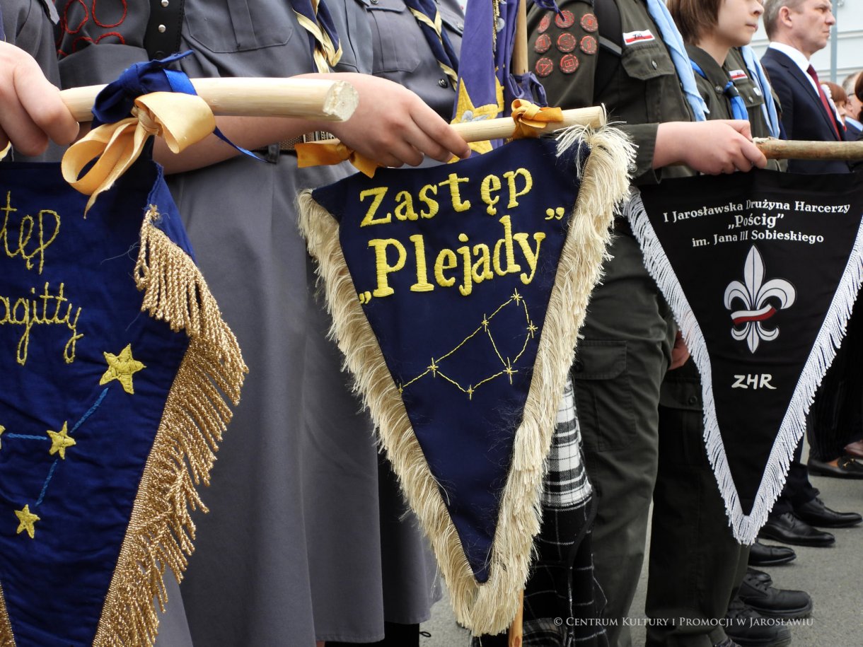 Początek maja to czas upamiętniający jedne z najważniejszych wydarzeń i symboli w naszej historii. Od 2004 roku w całej Polsce, 2 maja obchodzimy Dzień Flagi RP natomiast 3 maja przypada Święto Narodowe Trzeciego Maja. Dzień Flag RP to święto wprowadzone na mocy ustawy z 20 lutego 2004 r. Jarosławskie obchody Święta Flagi RP rozpoczęły się uroczystym przemarszem z placu ks. Piotra Skargi na jarosławski Rynek. Biało-czerwony korowód niosący 30-metrową flagę prowadzony był przez Orkiestrę Dętą „Laudate Dominum” oraz kompanię reprezentacyjna Wojska Polskiego. Po dotarciu na rynek, uroczyście podniesiono flagę na masz. Towarzyszył temu odegrany przez „Laudate Dominum” oraz odśpiewany przez żołnierzy i wszystkich zebranych Mazurek Dąbrowskiego. Okolicznościowe przemówienie wygłosił min. Burmistrz Miasta Jarosławia Waldemar Paluch, który podkreślał wagę symboli narodowych w tym szczególnym czasie, po czym miała miejsce defilada wojskowa. Na zakończenie obchodów rozdane zostały biało-czerwone flagi, wykonano wspólne pamiątkowe zdjęcie, a dzieci mogły wziąć udział w specjalnie dla nich przygotowanych animacjach i zabawach. Święto Narodowe Trzeciego Maja otworzył koncert Reprezentacyjnego Chóru Mieszanego „Jarosław”, który poprzedził mszę święto w intencji Ojczyzny, odprawioną w kościele p.w. NMP Królowej Polski. Po eucharystii udano się pod pomnik Konstytucji Trzeciego Maja gdzie w towarzystwie Mazurka Dąbrowskiego podniesiono flagę na maszt. Po okolicznościowych przemówieniach odczytana apel pamięci, następnie kompania honorowa Wojska Polskiego oddała salwę honorową. Później nastąpiło złożenie kwiatów pod Pomnikiem przez władze parlamentarzystów, władze wojewódzkie i samorządowe, służby i instytucje publiczne, organizacje pozarządowe oraz szkoły.