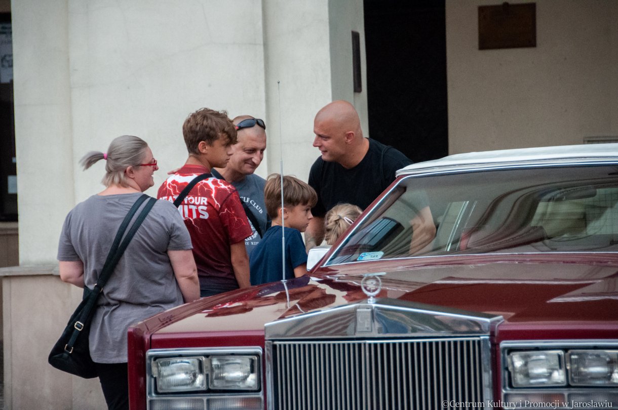 ludzie oglądają stare samochody