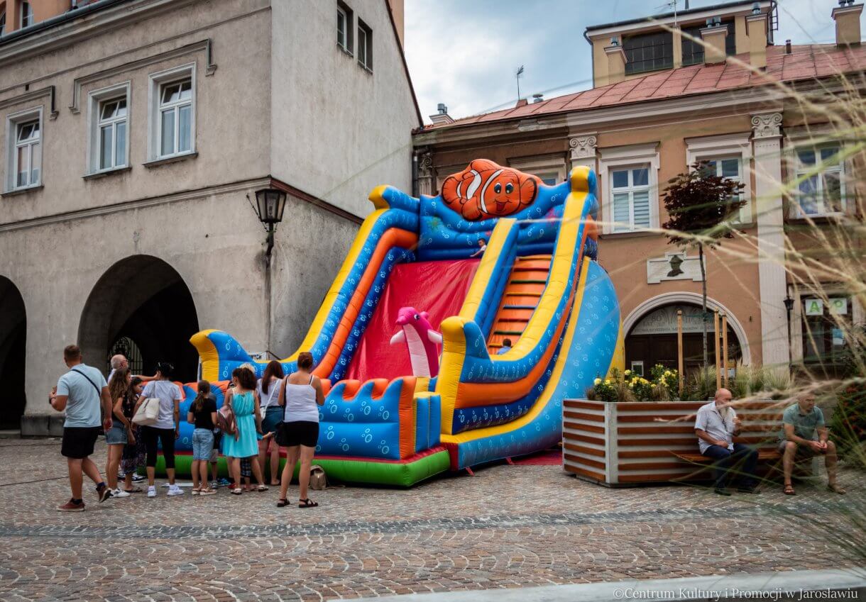 dmuchana zjeżdżalnia z bawiącymi się na niej dziećmi