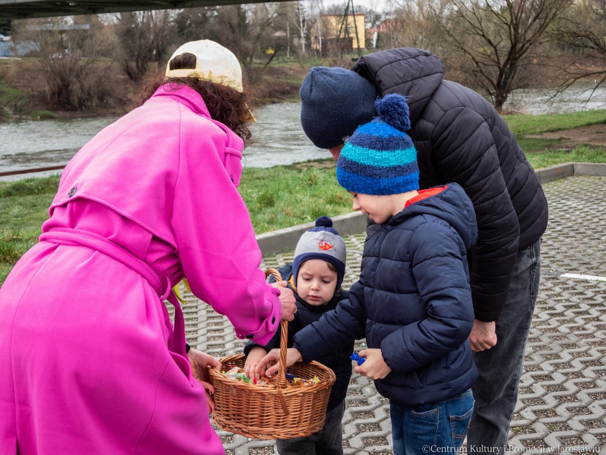 prowadząca piknik z okazji powitania wiosny rozdaje najmłodszym uczestnikom wydarzenia słodycze