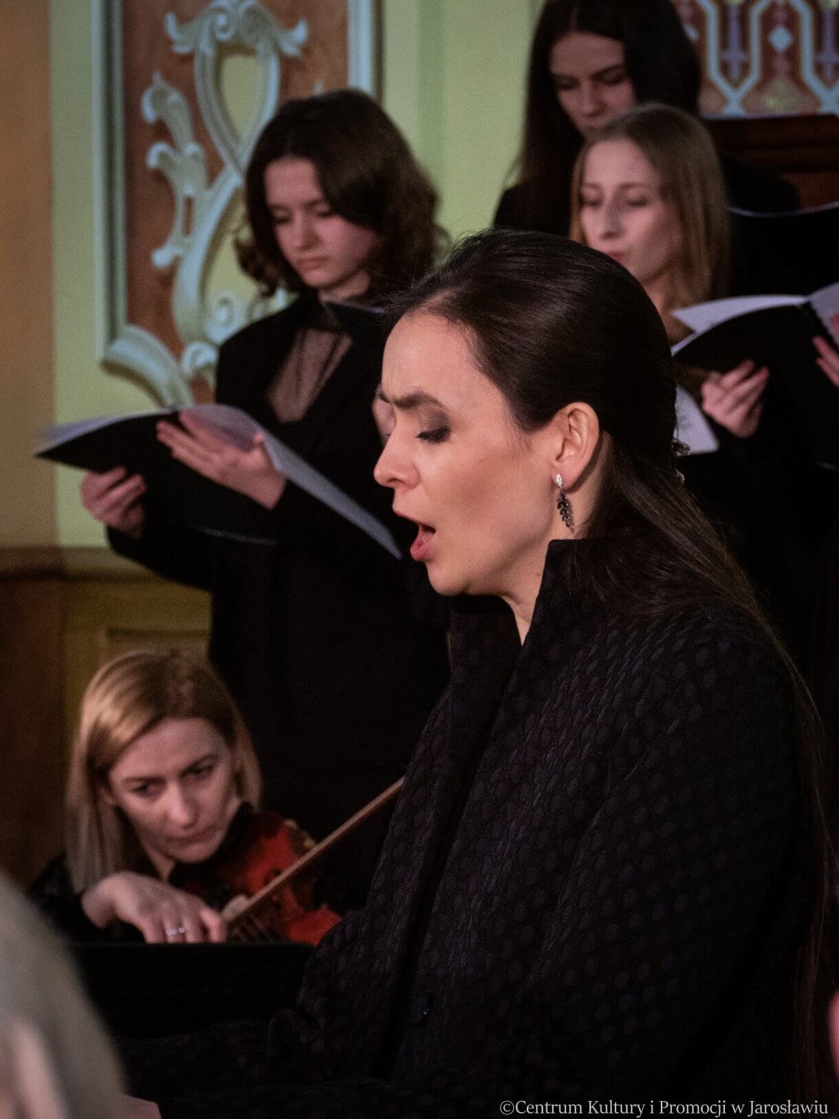 Koncert w kolegiacie - solistka Aneta Nurcen, w tle chór i skrzypaczka