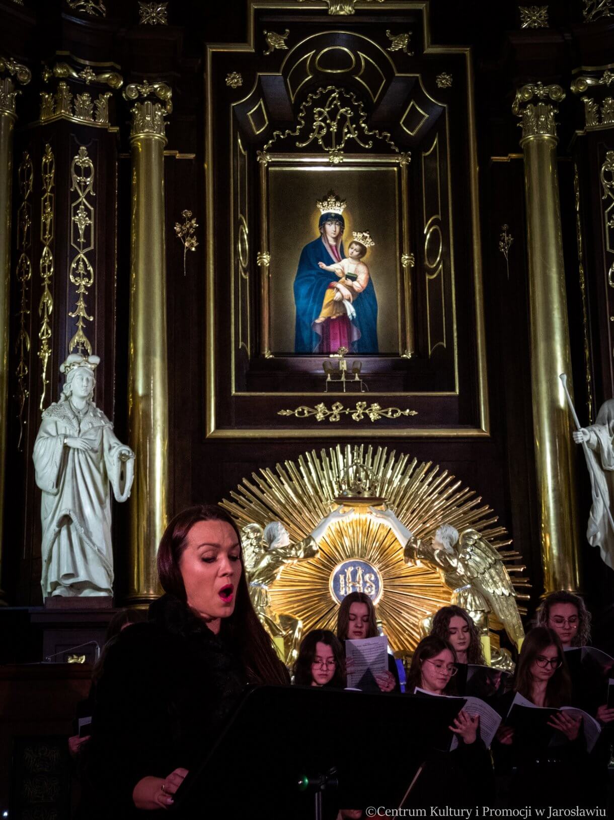 Koncert w kolegiacie - solistka Renata Dżonson-Wojtowicz, w tle obraz w ołtarzu