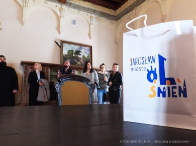 Spotkanie lokalnej branży hotelarskiej W tle grupa ludzi, z przody torba z logo Jarosław Miasto Olśnień