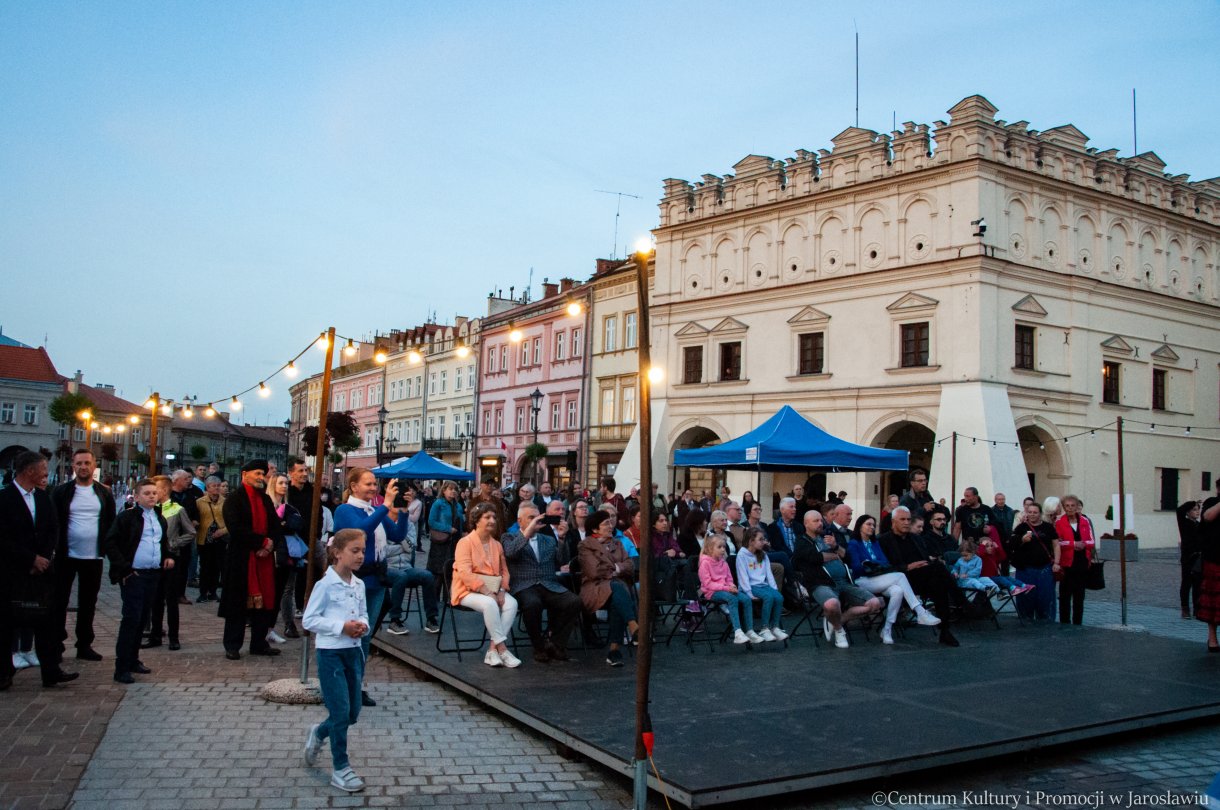 uczestnicy jarosławskiej Nocy Zwiedzania Rynku podczas oglądania programu artystycznego w tle zabytkowe kamienice przy rynku