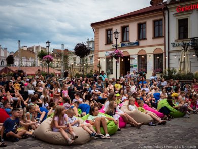 Kulturalne Lato 2023! dzieci oglądające spektakl w tle jarosławskie kamienice