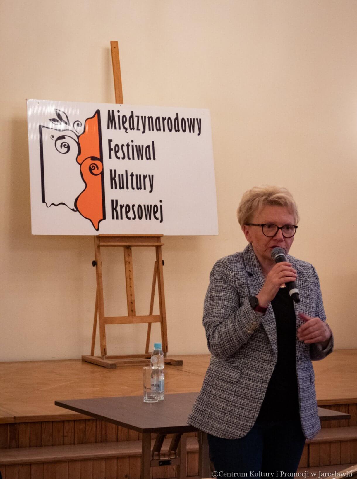 Prezes Stowarzyszenia Dziedzictwo Kresów w tle tablica Międzynarodowego Festiwalu Kultury Kresowej