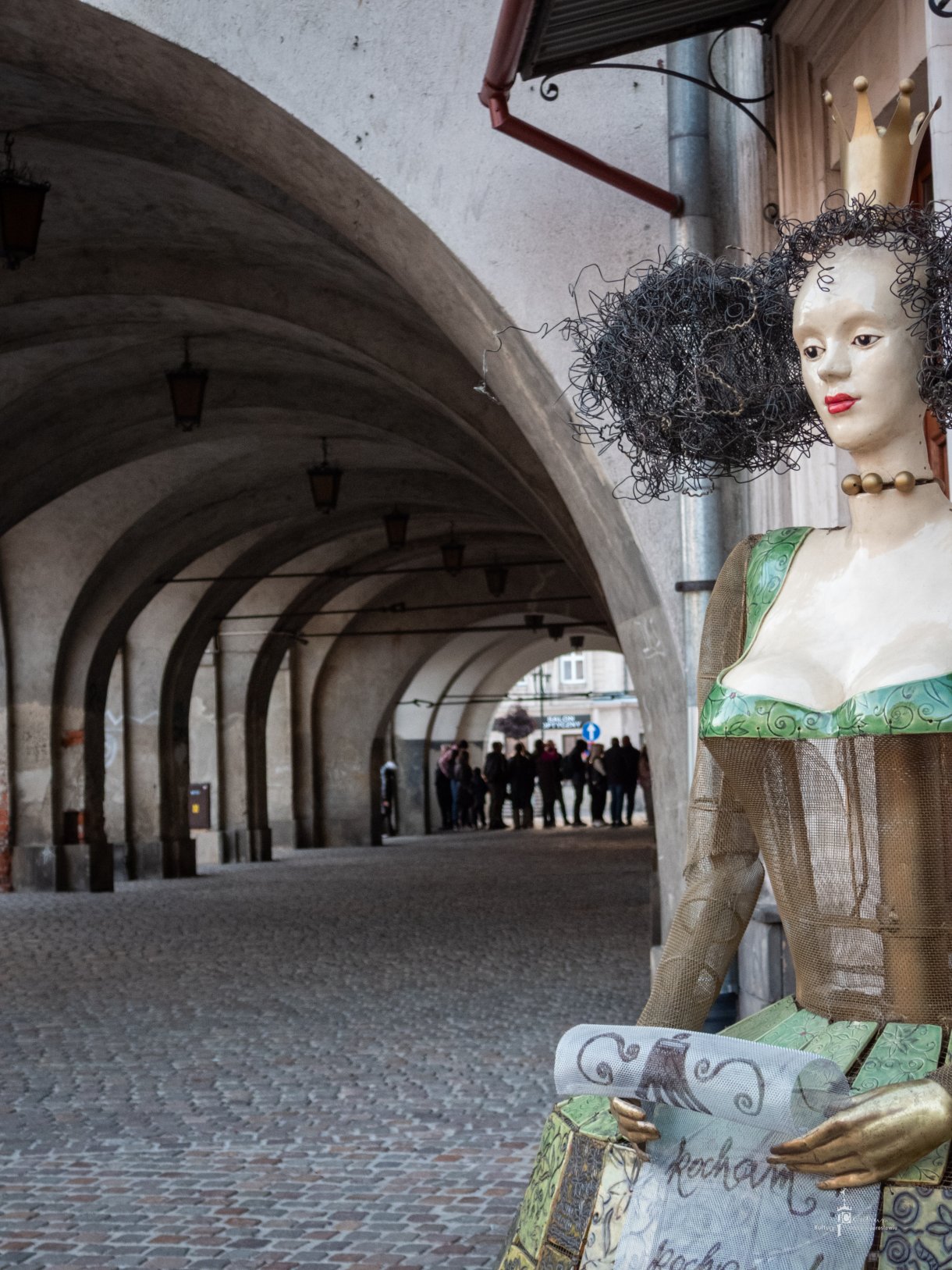 Noc Zwiedzania Rynku - zwiedzanie miasta, na pierwszym planie królowa Marysieńka w tle kolejka do podziemi