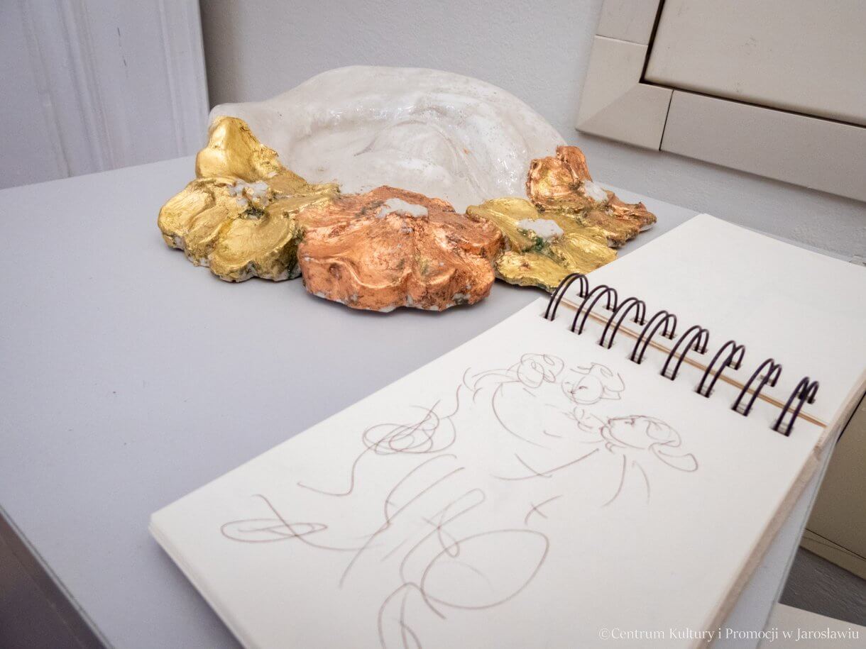 Wystawa prac Marioli Gaweł i Huberta Sawka w Galerii Debiutów - na pierwszym planie szkicownik na drugim rzeźba