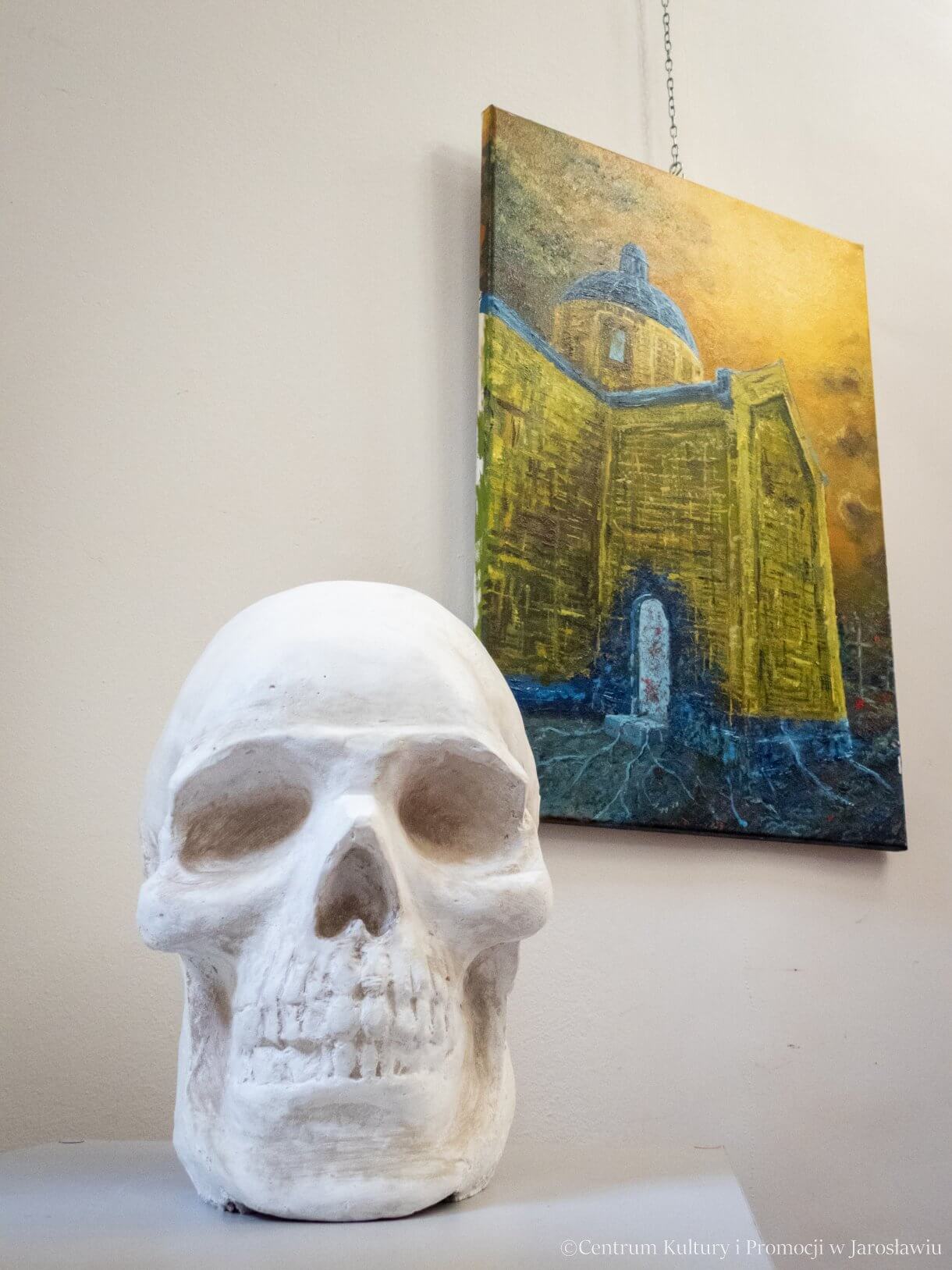 Wystawa prac Marioli Gaweł i Huberta Sawka w Galerii Debiutów - na pierwszym planie rzeźba (czaszka) w tle obraz (malarstwo na płótnie)